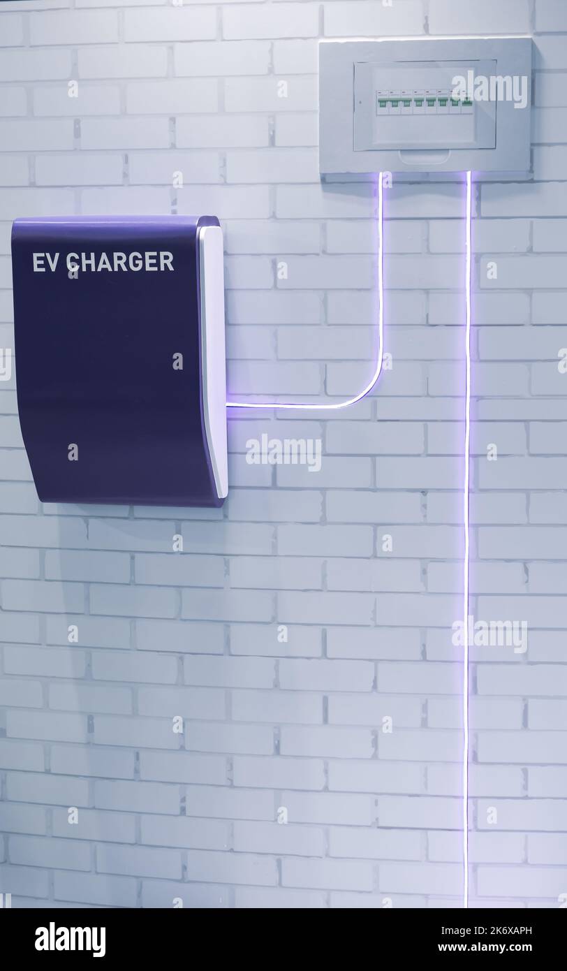 Concept of EV electric car home charging point in garage Stock Photo