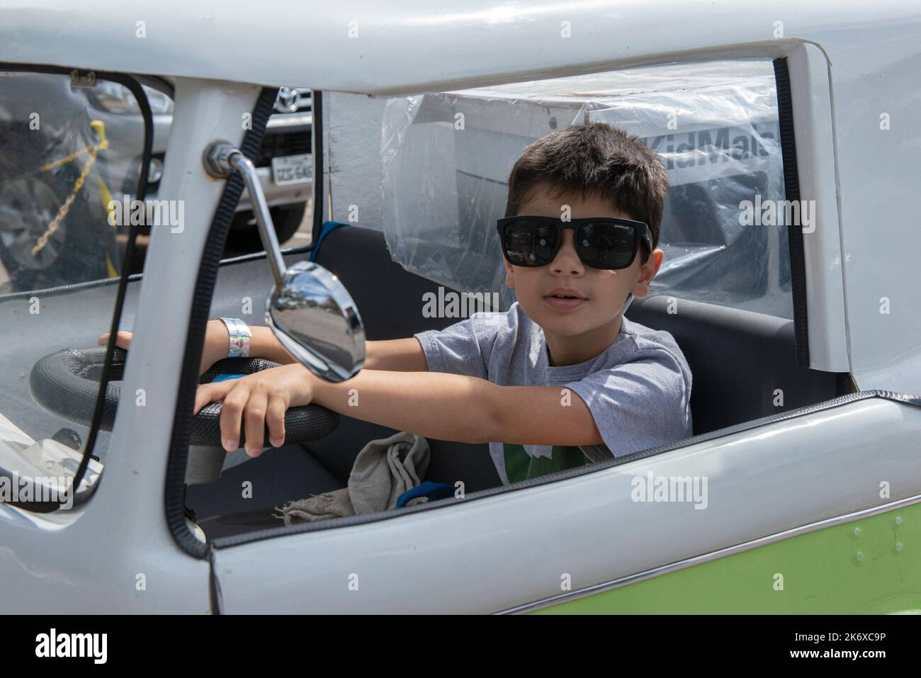 Atibaia - Brazil, October 7, 2022: Boy in sunglasses posing in a miniature van replica of the Scooby Doo mystery machine and the gang, Shaggy, Fred, D Stock Photo