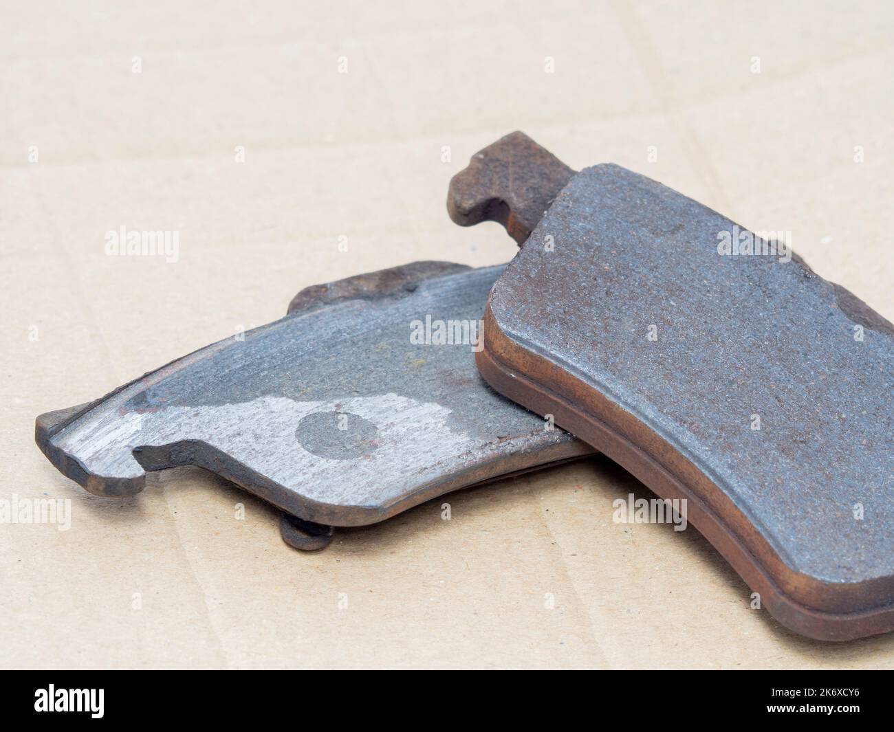 Used damaged brake pads need to change, close up. Stock Photo