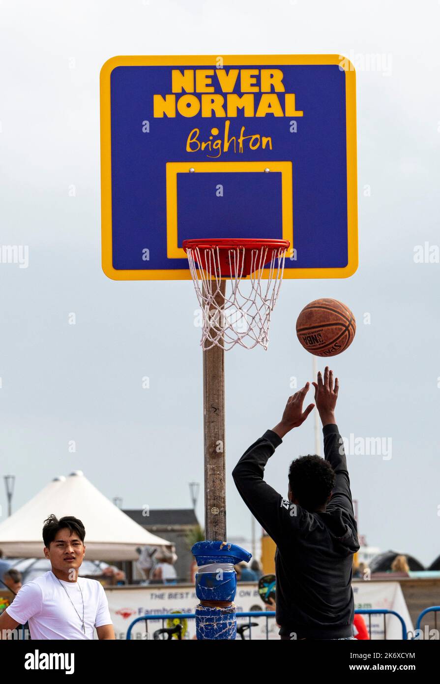 Brighton UK 16th October 2022 - Never Normal as basketball players enjoy a warm day on Brighton  seafront as more unsettled weather is forecast for the next few days in the UK : Credit Simon Dack / Alamy Live News Stock Photo