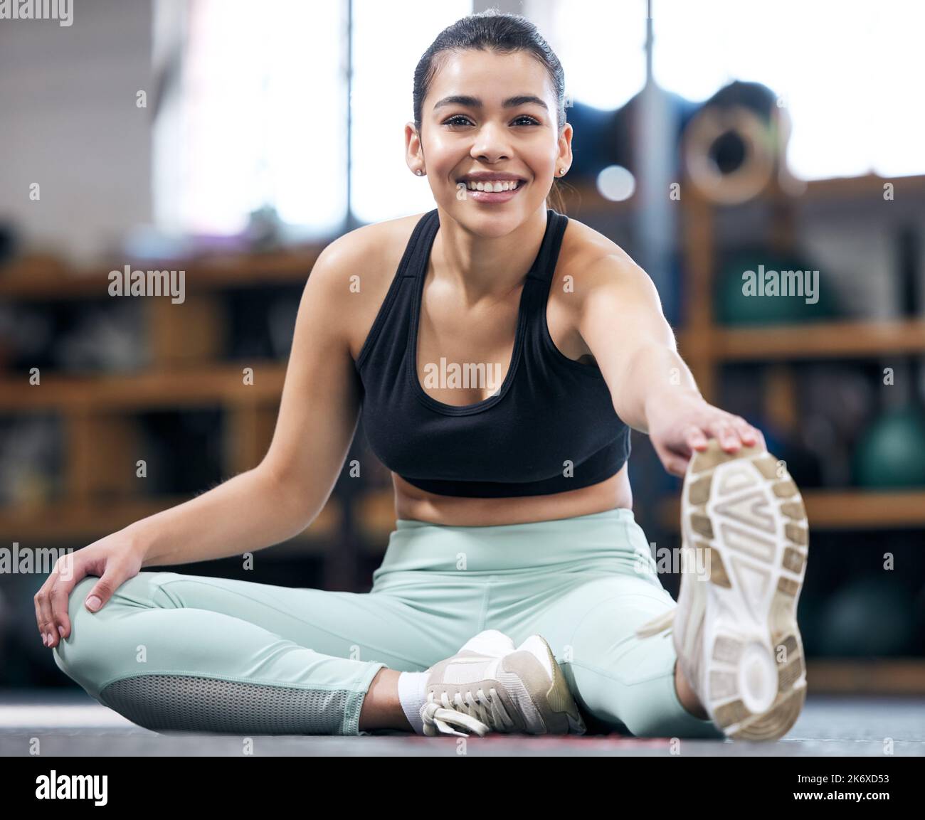 The warmup is half of the workout. Portrait of a fit young woman stretching in a gym. Stock Photo