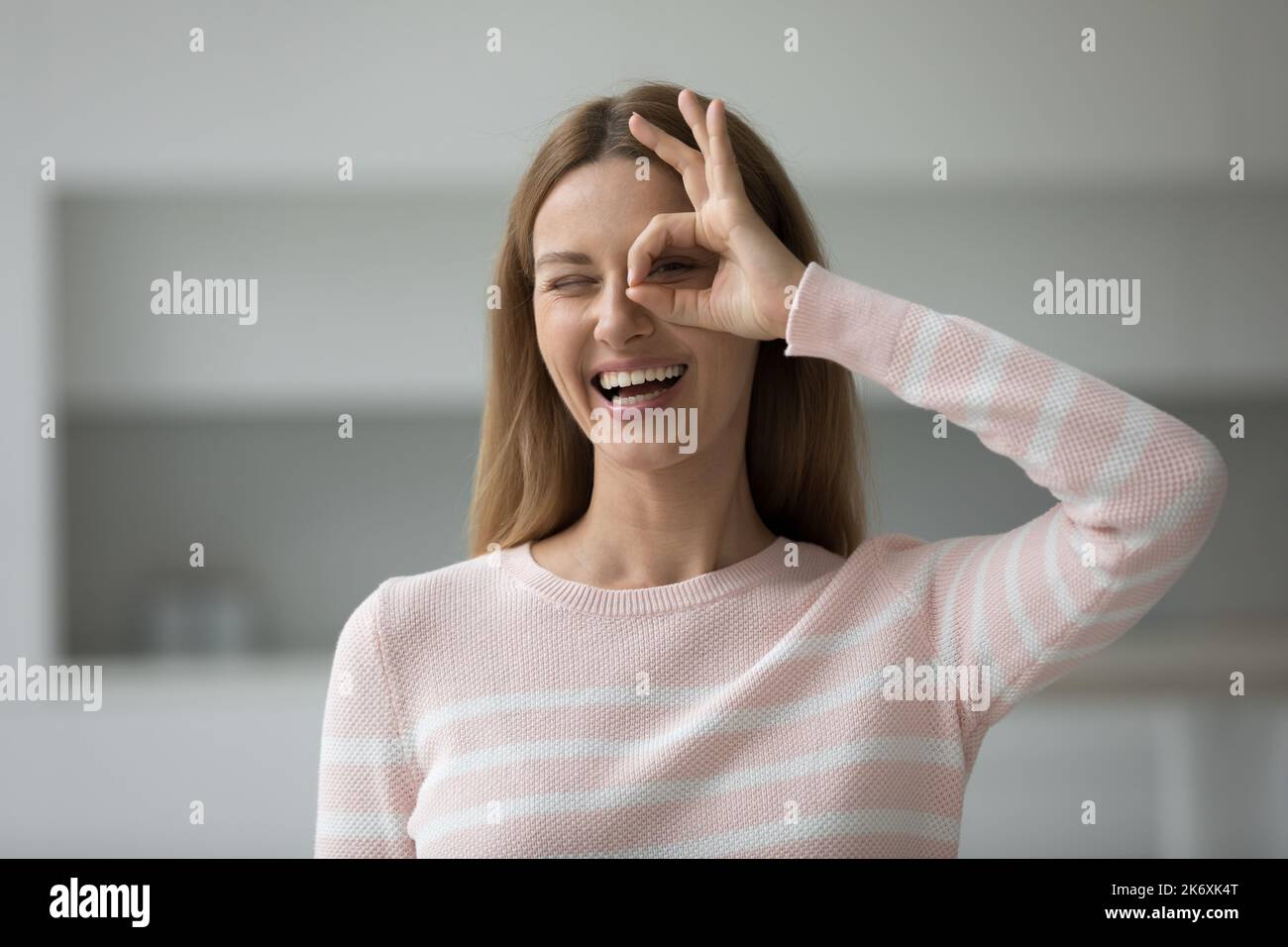 Head shot portrait smiling woman showing binocular shape with fingers Stock Photo