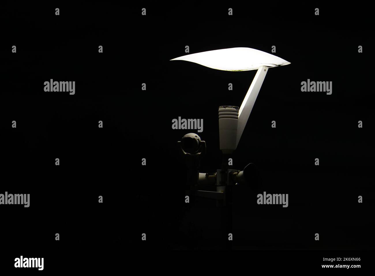 Light Pole with Security Camera equipment over black background. Isolated Stock Photo