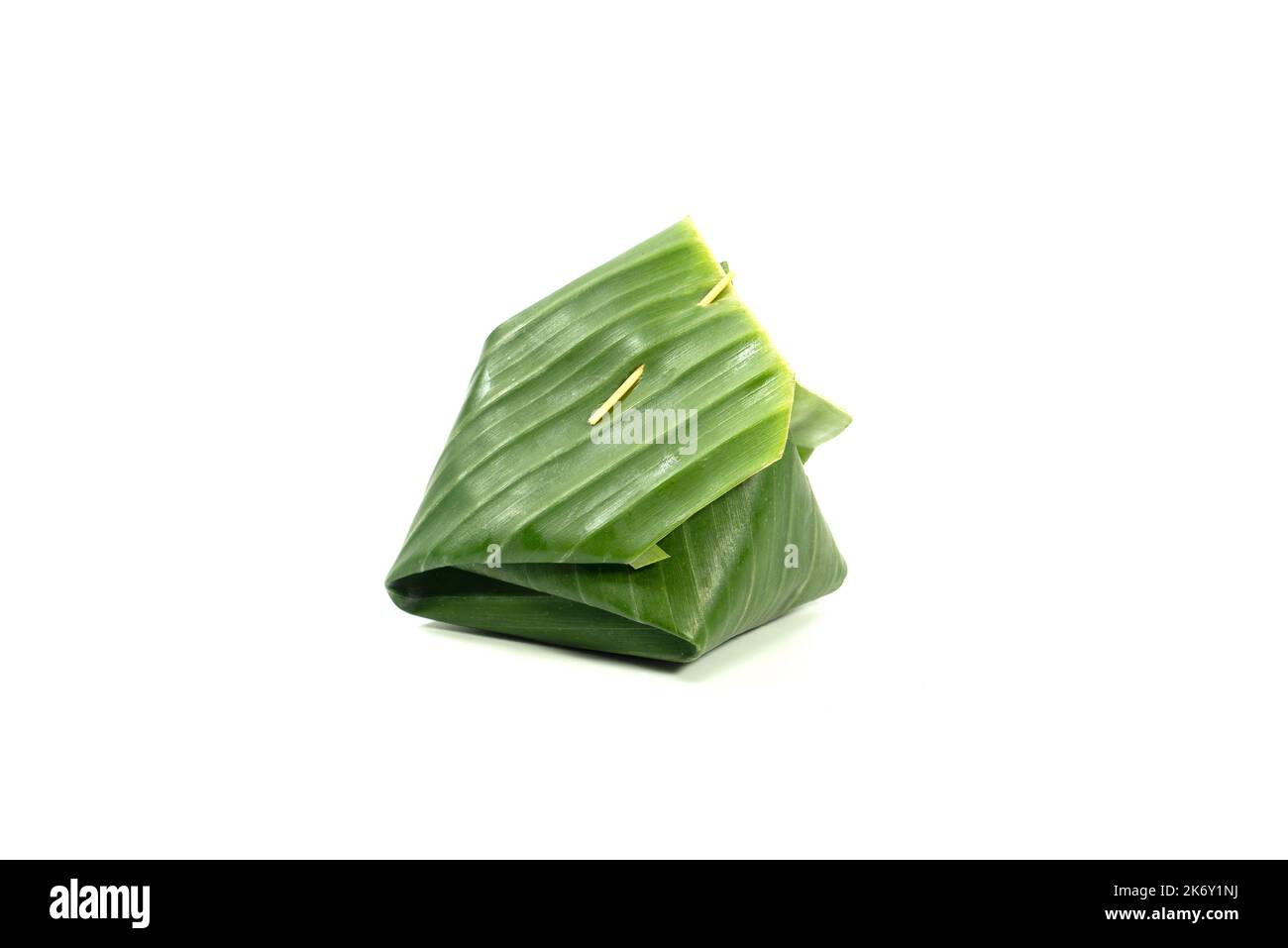 Wrapping Thai desserts with banana leaves, isolated on white background