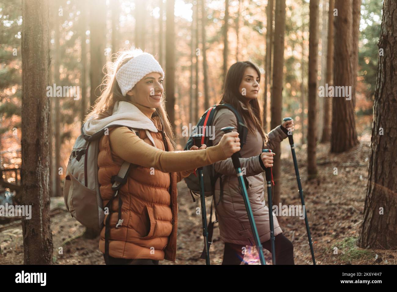 Two girls climbing up the hill together. Autumn colors Stock Photo - Alamy