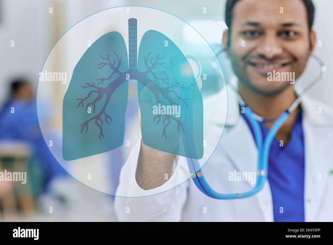 Hindu doctor pulmonologist auscultation of holographic human lungs with stethoscope, standing on hospital hallway. Lungs health concept Stock Photo