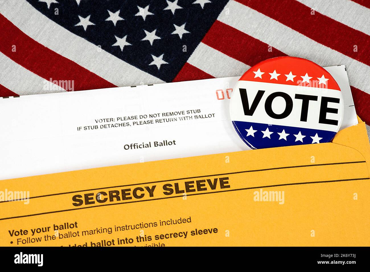 Vote button on mail-in ballot with envelope on an American flag Stock Photo