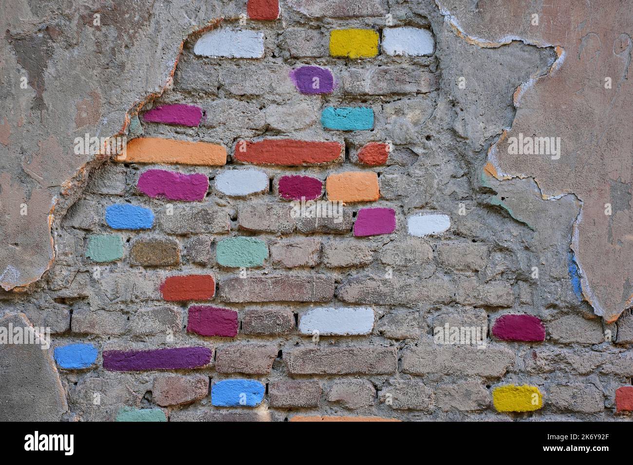 Wand mit beschädigtem Putz und bunt angemalten Ziegelsteinen, mittelalterliches Stadtzentrum Kala, Altstadt, Tiflis, Georgien Stock Photo