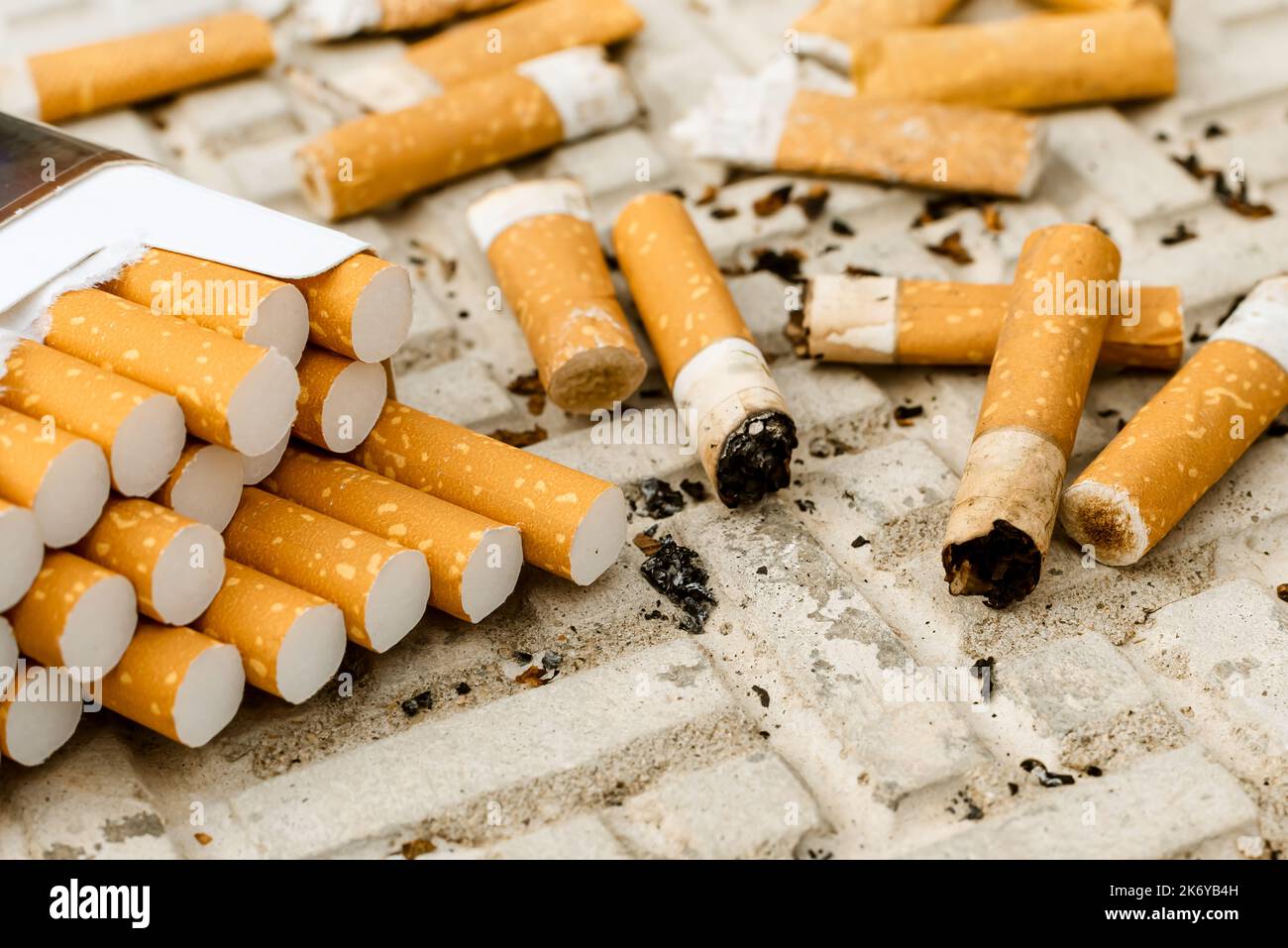 Cigarette. A lot of cigarette butts and matches are lying on the road