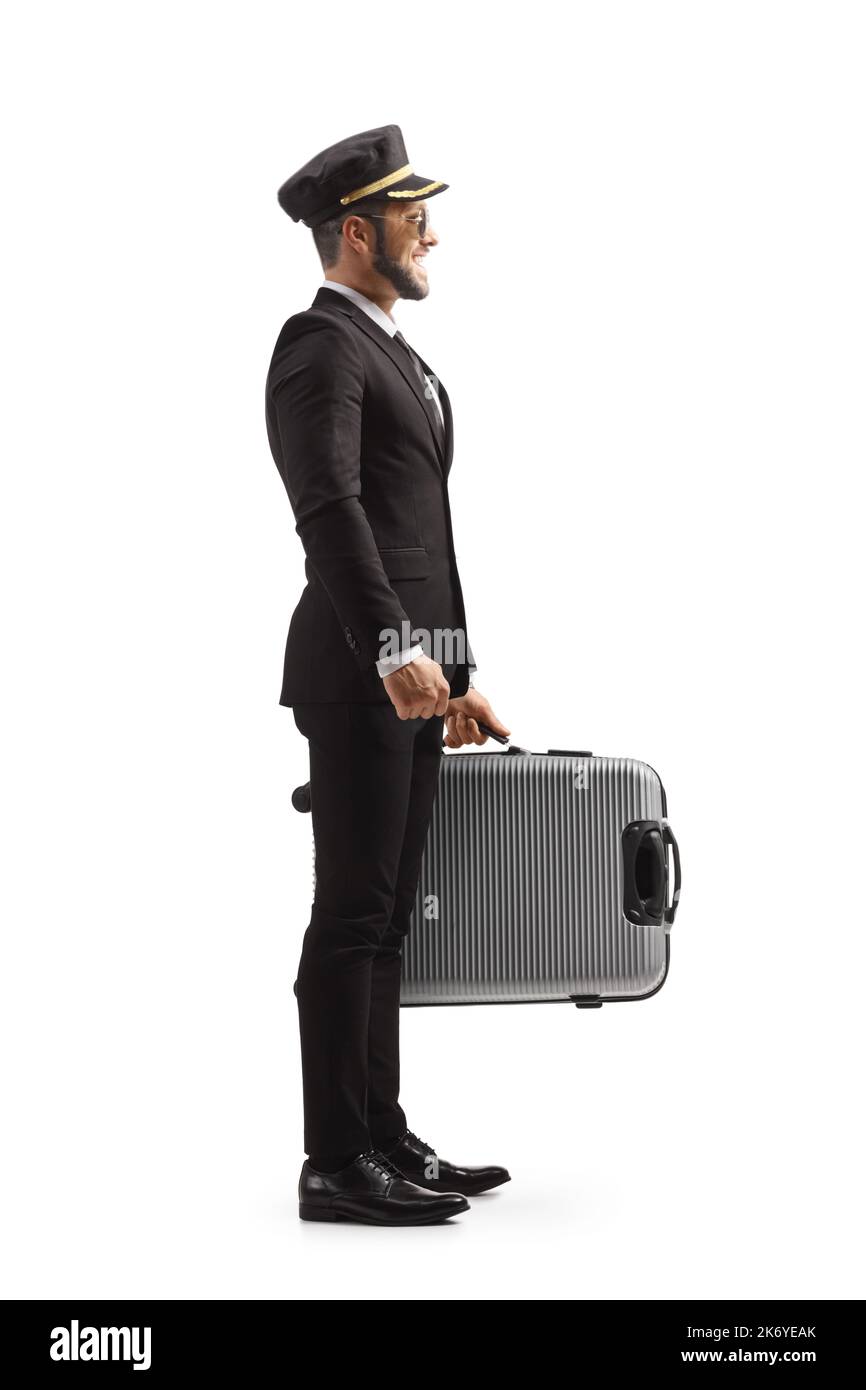 Full length profile shot of a pilot in a uniform standing and holding a suitcase isolated on white background Stock Photo