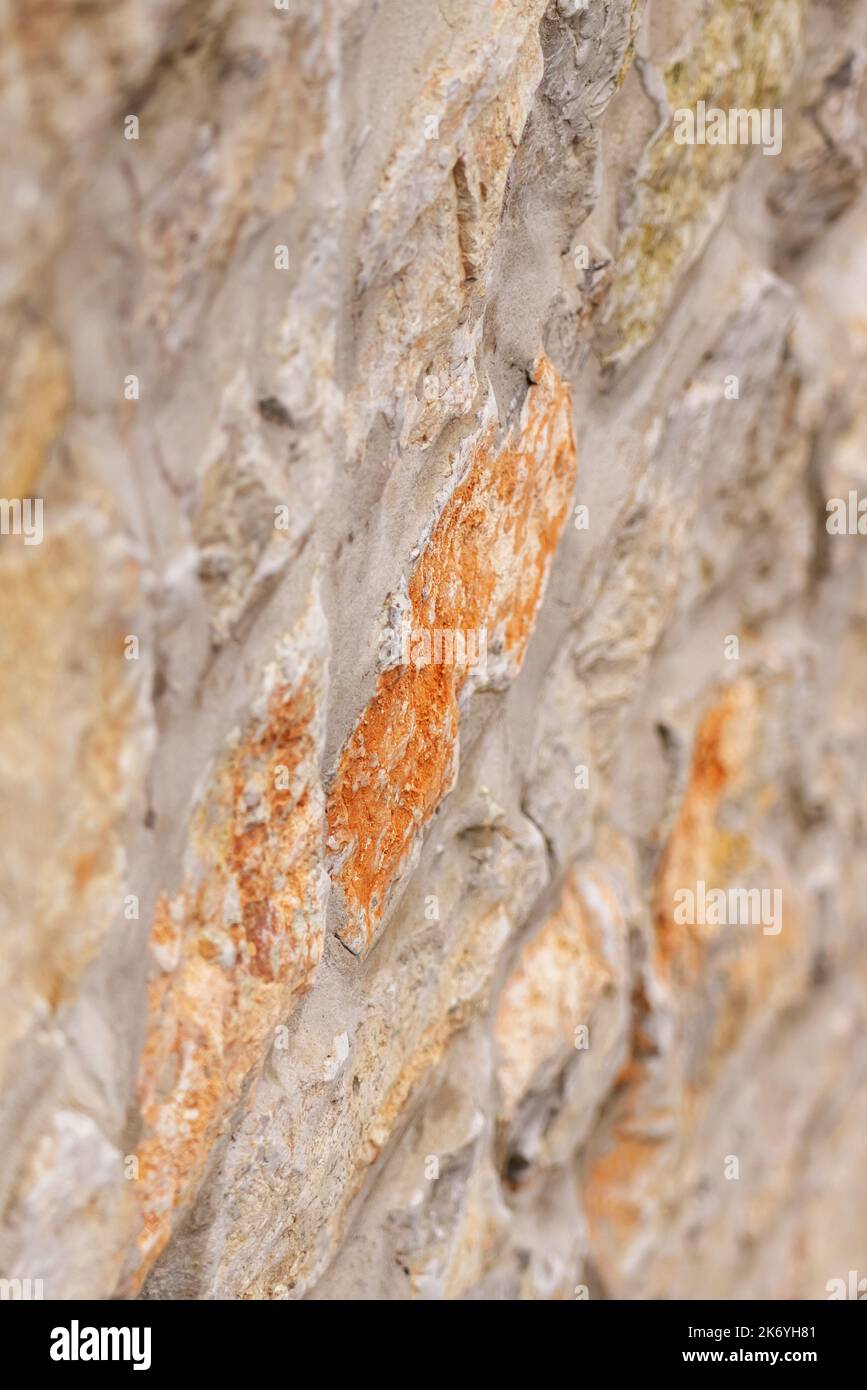 Stone wall. Uneven rough rock surface. Abstract brown background. Vertical view Stock Photo