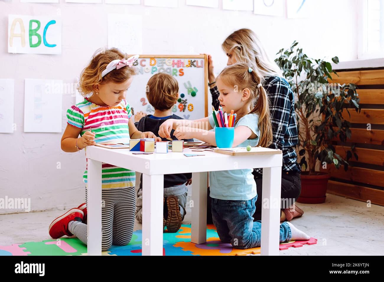 Children having fun and learning in kid development center or school