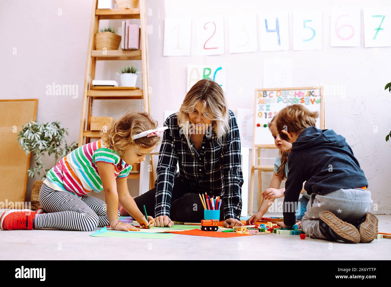 Female psychiatrist play and learn with children, make crafts, handmade