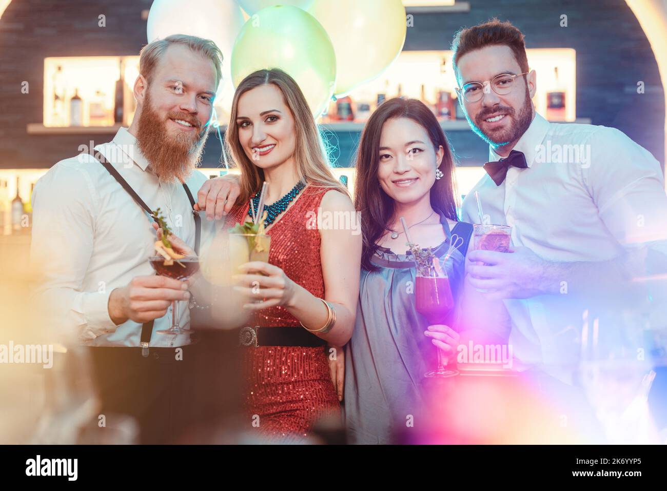 Diverse happy young friends enjoying drinks at party Stock Photo