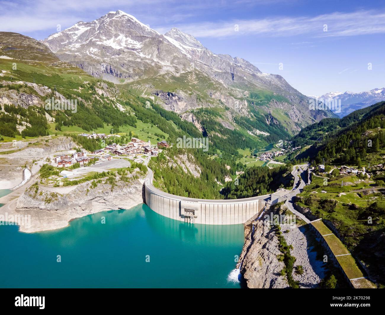 Water dam and reservoir lake aerial view in Alps mountains generating hydroelectricity. Low CO2 footprint, decarbonize, renewable energy, sustainable Stock Photo