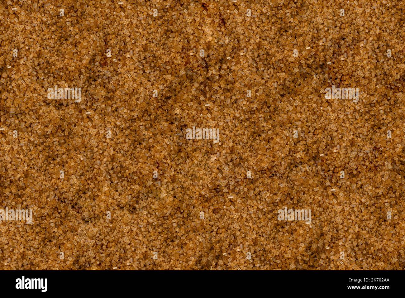 High angle full-frame photo of brown sugar grains making pattern for