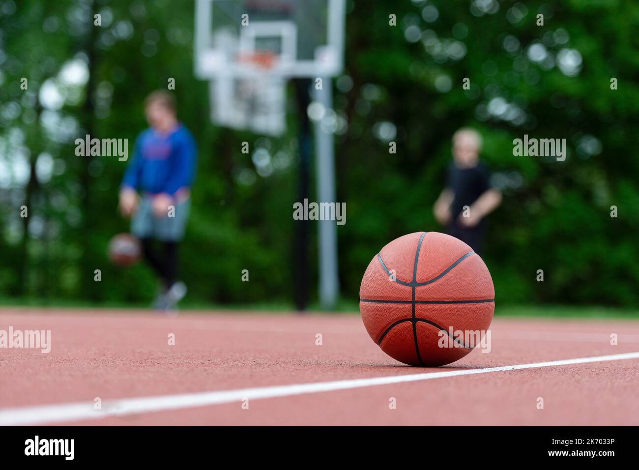 Orange basketball on brown court of gymnasium sport floor. Street