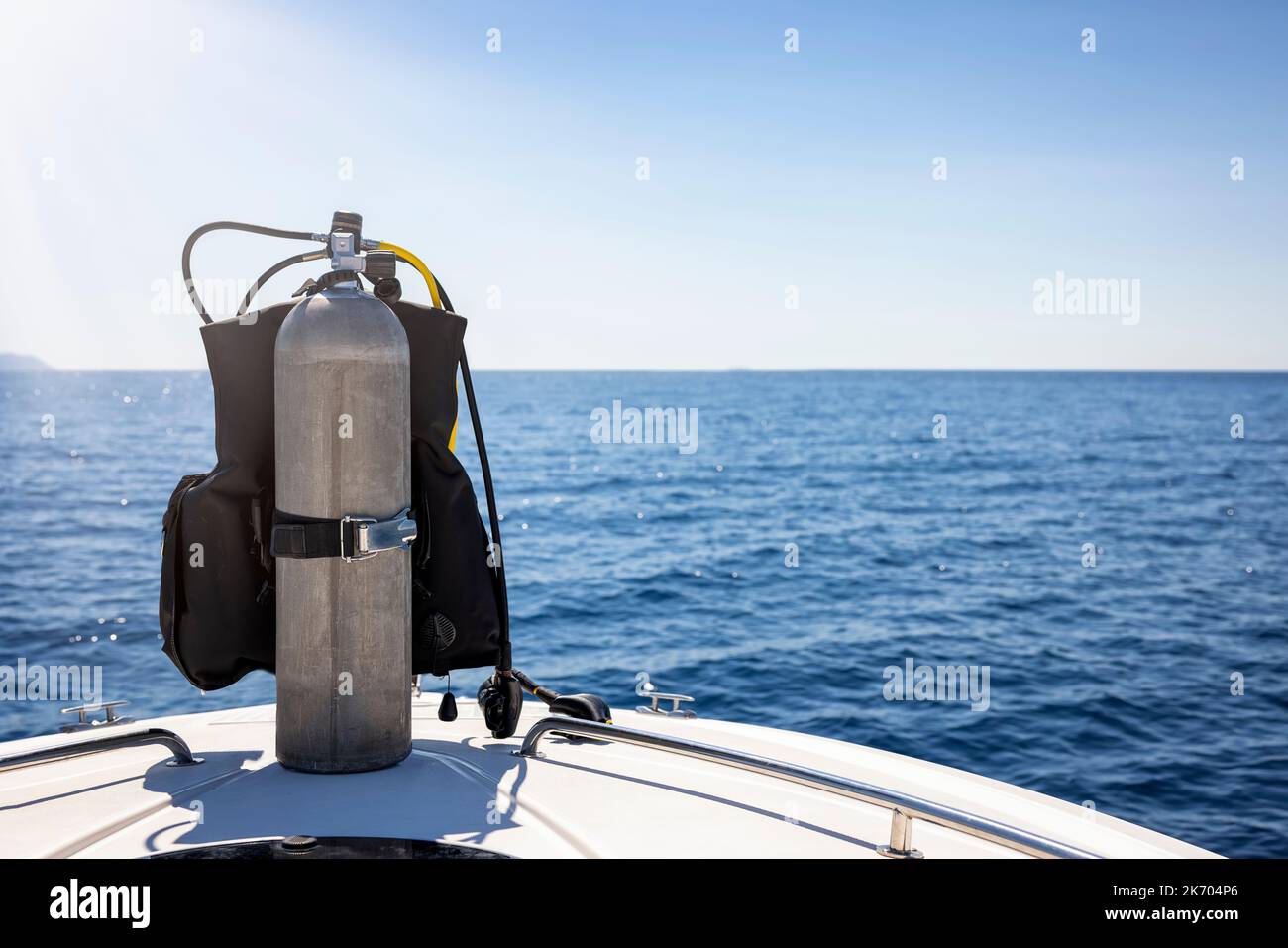 A scuba diving tank and gear standing on a boat Stock Photo