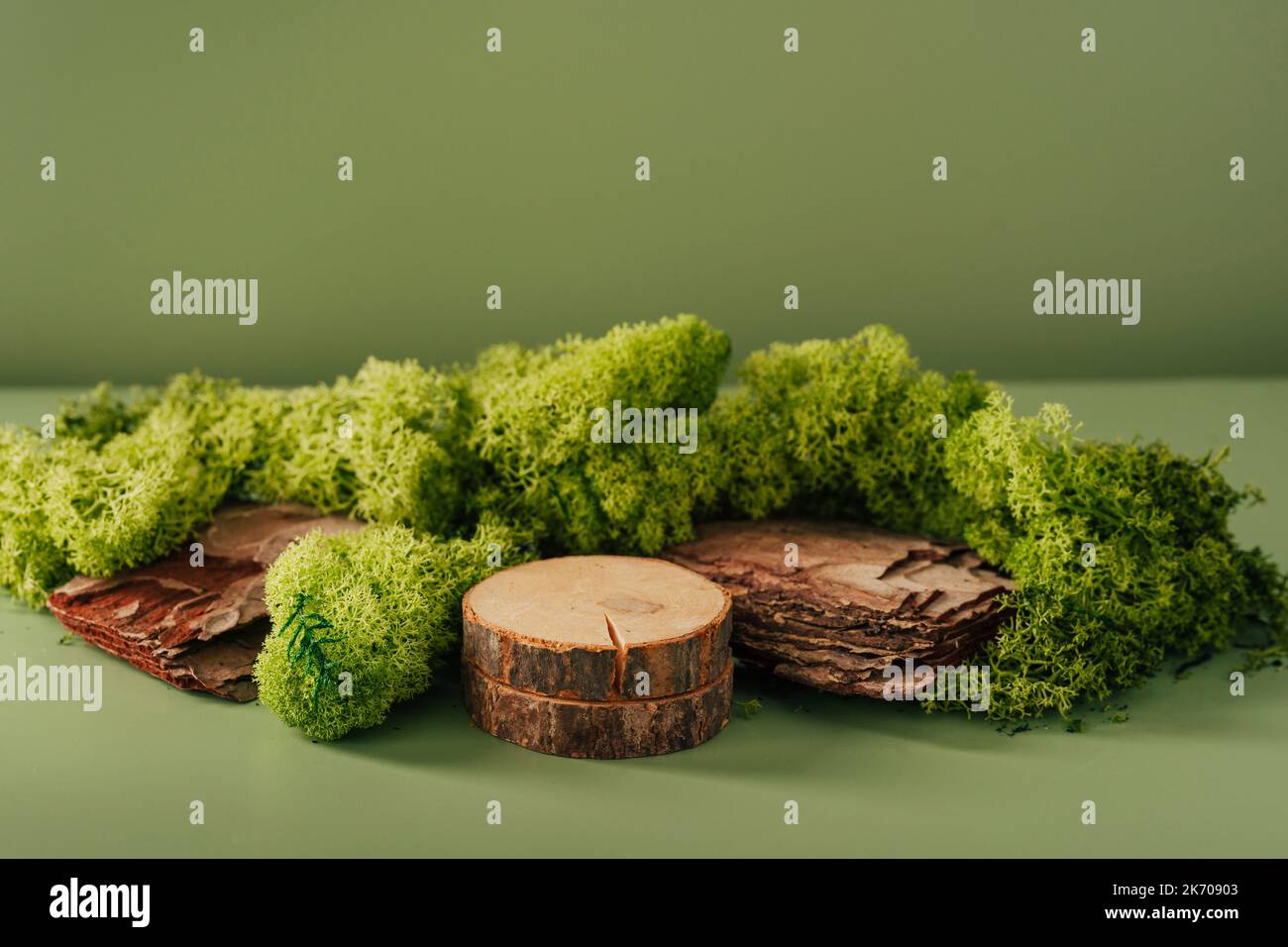 Composition of bark tree and moss on warm green background. Abstract podium for organic cosmetic products. Natural stand for presentation and exhibitions. Minimal design Stock Photo