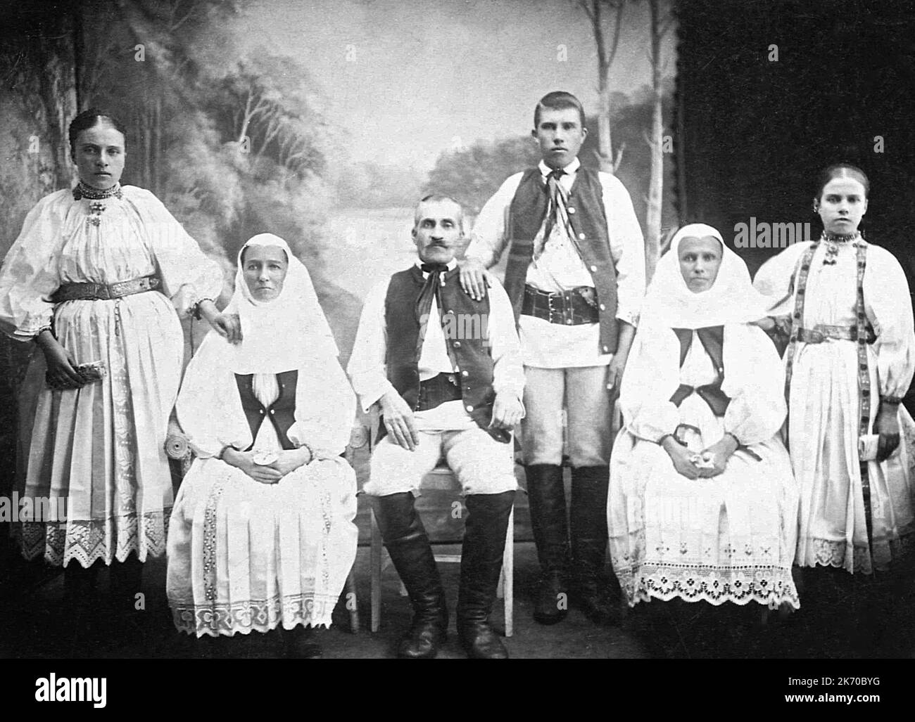 Members of the Saxon community in traditional folk costumes posing for a photography. Black & white vintage photo from the first half of the 19th century in Brasov County, Transylvania, Romania. Stock Photo