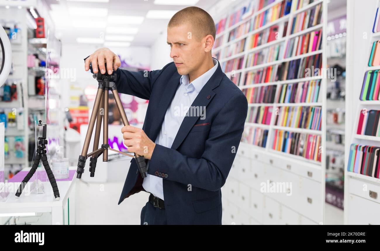 Male customer buying tripod at the multimedia store Stock Photo Alamy