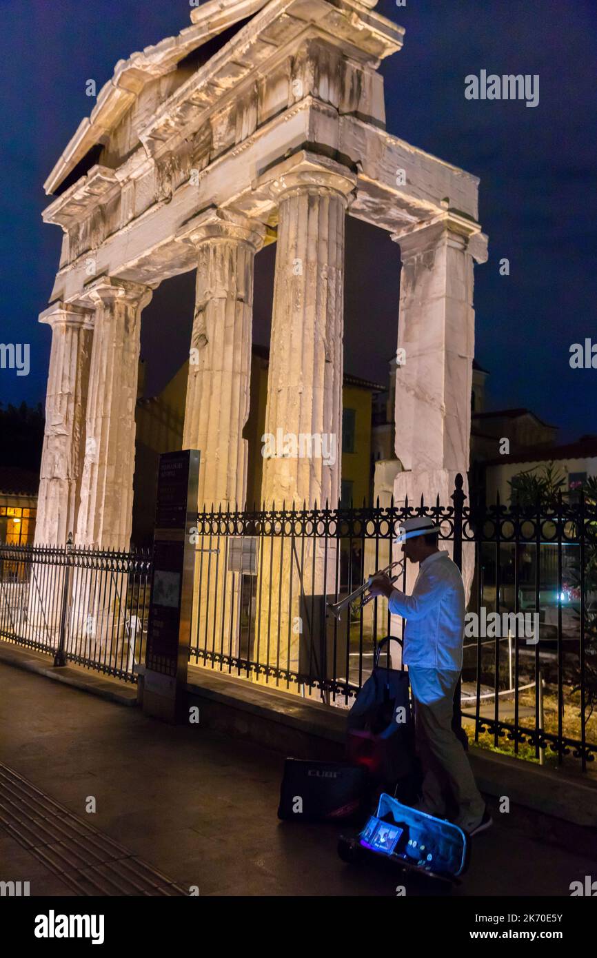 Street musician plays the trumpet at night in front of ruins Stock Photo