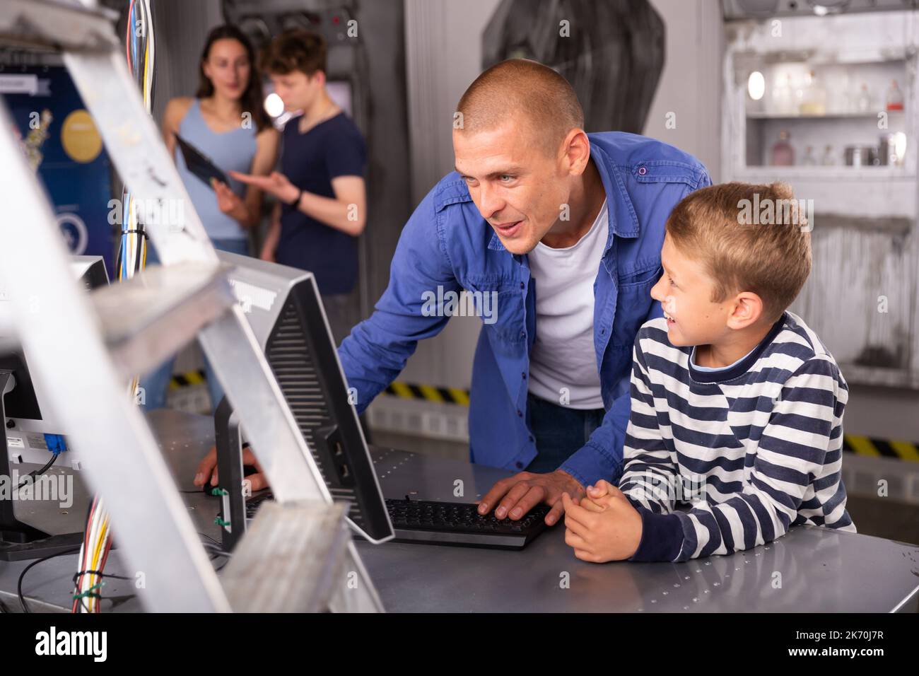 Portrait of a father and son in front of a computer in the quest room ...