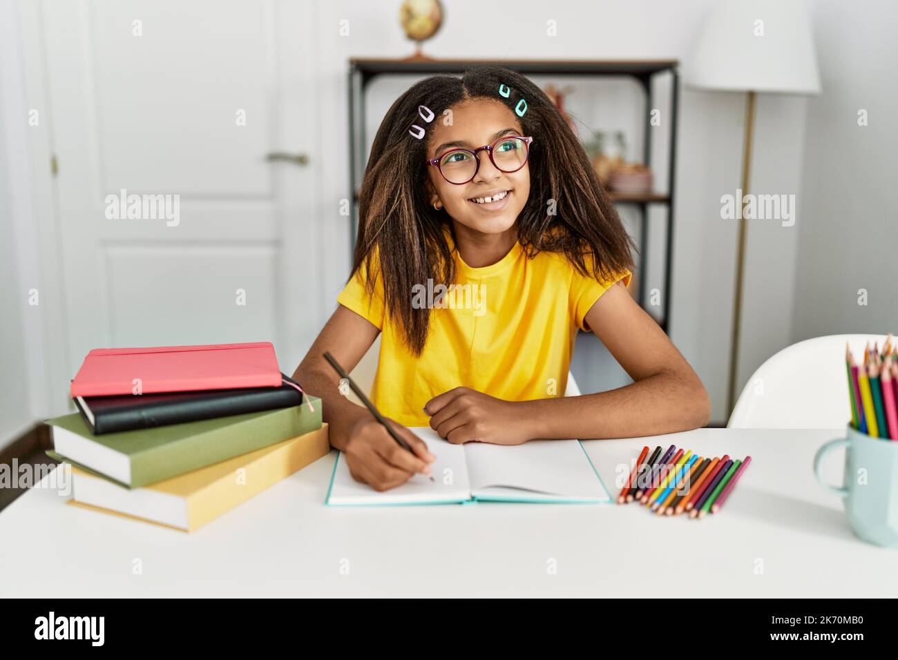 African girl smiling book desk hi-res stock photography and images - Alamy