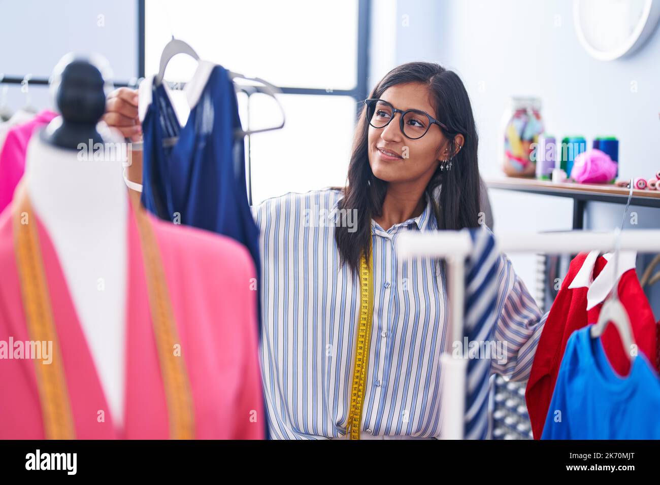 Hispanic Rack Young beautiful hispanic woman tailor smiling confident holding clothes ...