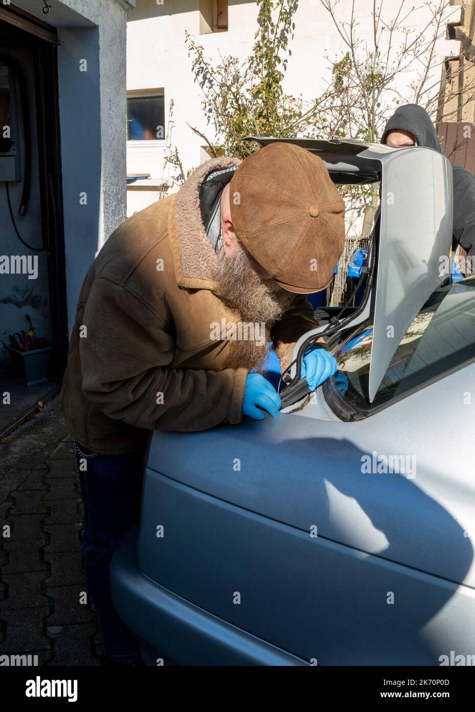 Mann repariert die Dichtung am Kofferraum eines Autos Stock Photo
