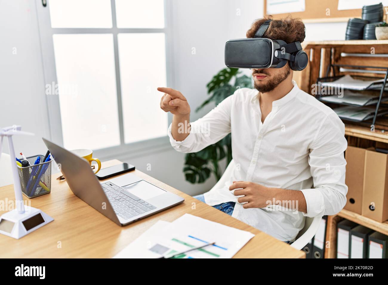Young arab man using vr goggles working at office Stock Photo