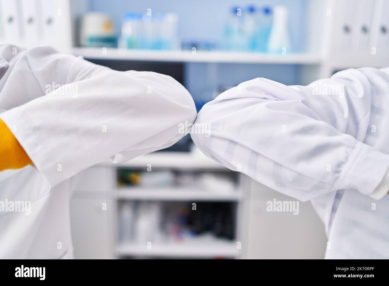 Two man scientists doing elbow greeting at laboratory Stock Photo