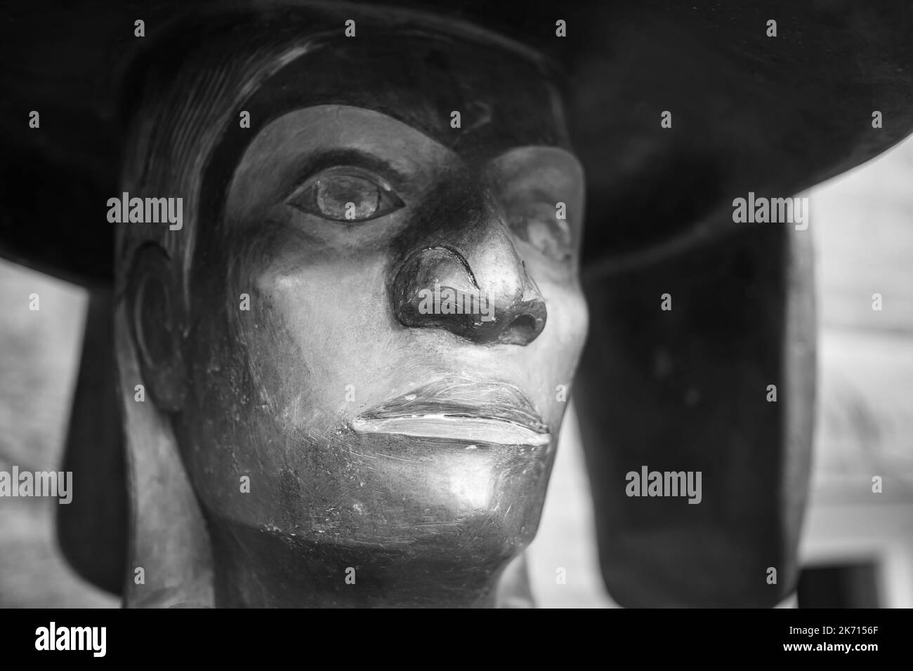 Wood carving of a man face, outdoors. Indigenous carving art. Soft blurred tree background-Quench Fountain, Duncan British Columbia, Canada-October 6, Stock Photo