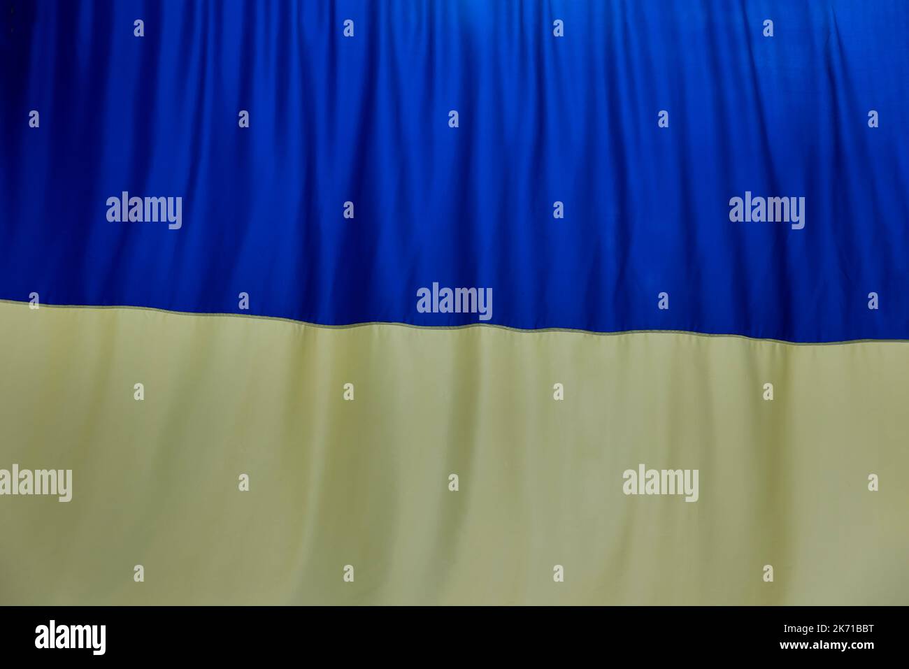 Blue and yellow colors fabric curved flag of Ukraine, UA Stock Photo