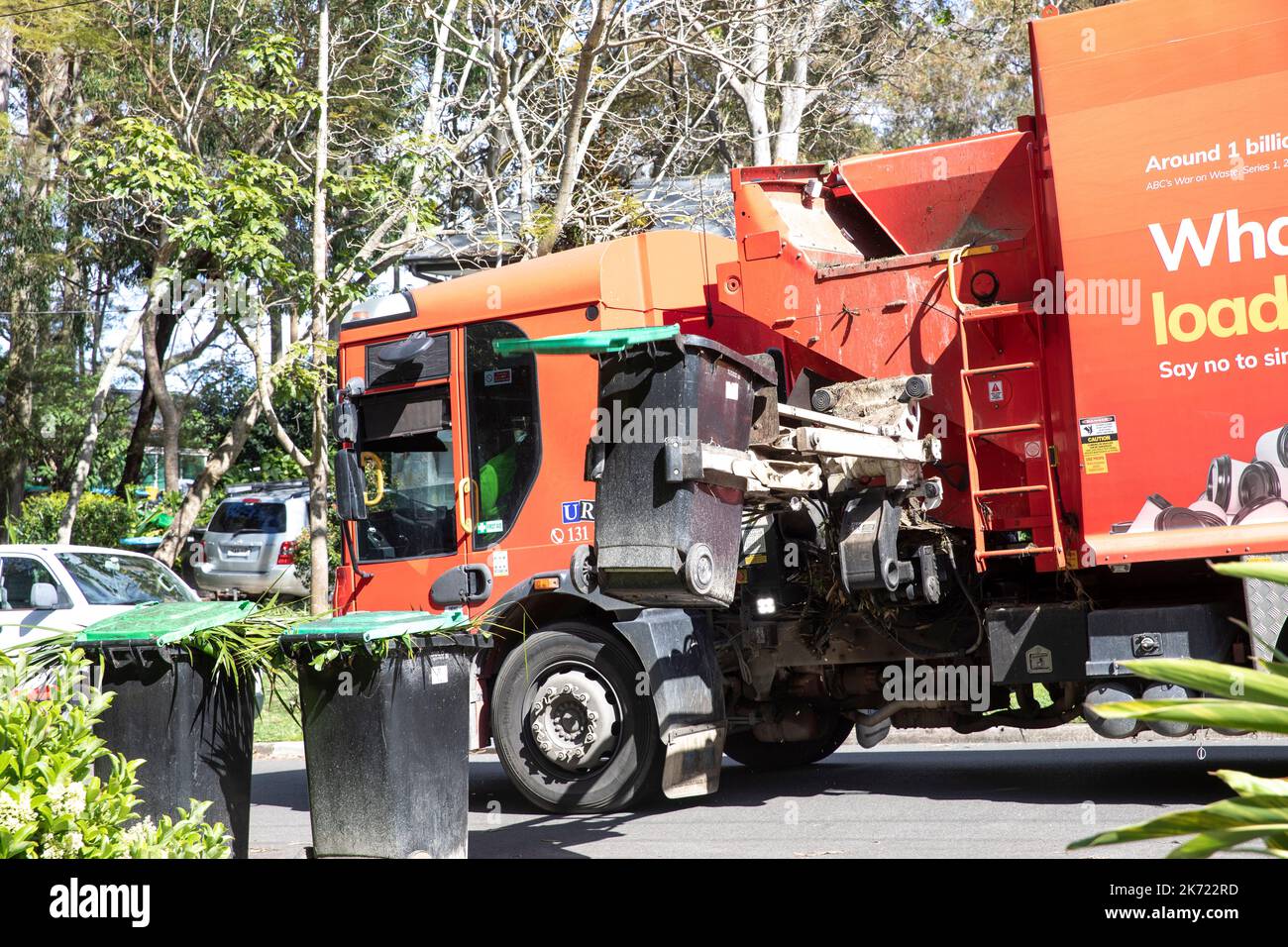 Australia, council vehicle picks up and empties green waste vegetation bins into collection
