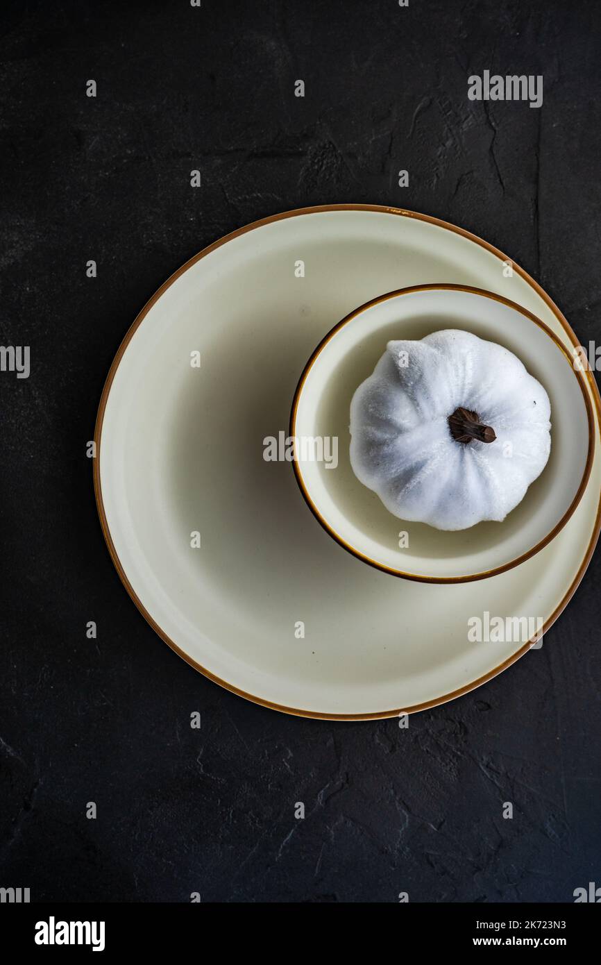 White pumpkin in table setting on dark concrete background Stock Photo