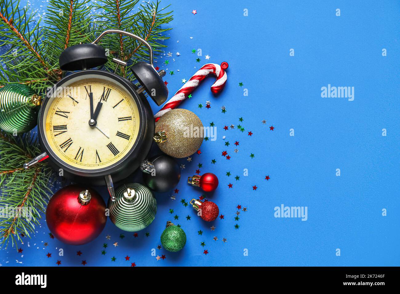 Vintage alarm clock with Christmas decor and fir branches on blue ...