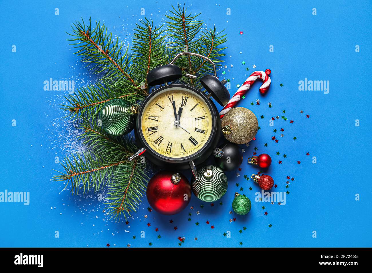 Vintage alarm clock with Christmas decor and fir branches on blue ...