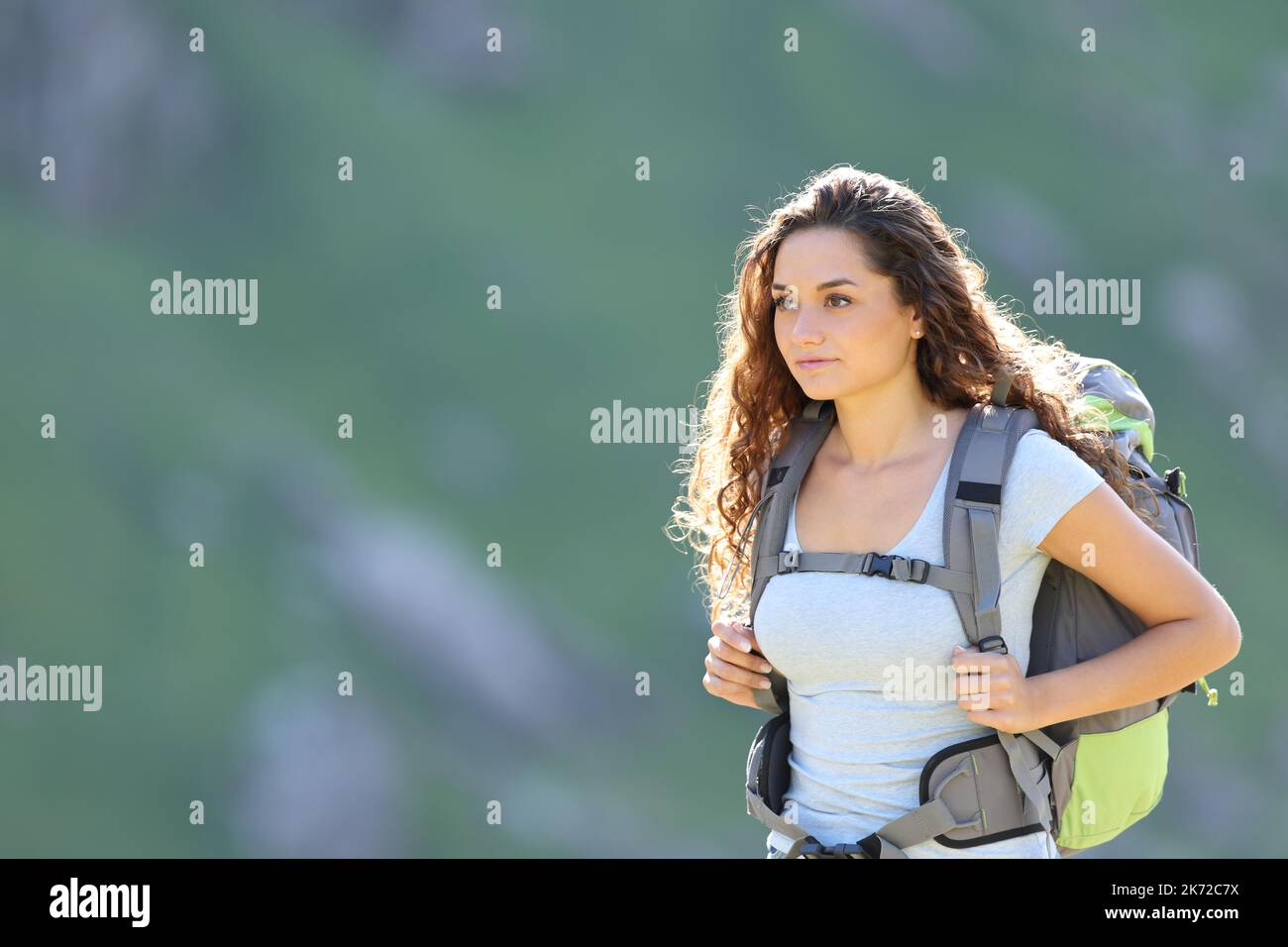 Hiker woman walking alone in the mountain wearing backpack Stock Photo