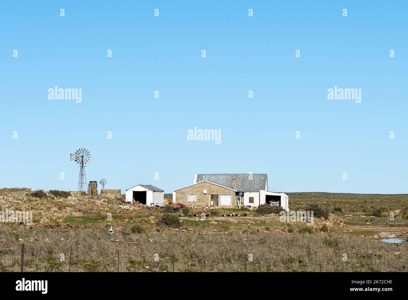 SUTHERLAND, SOUTH AFRICA SEP 4, 2022 Windmills, barn and house at