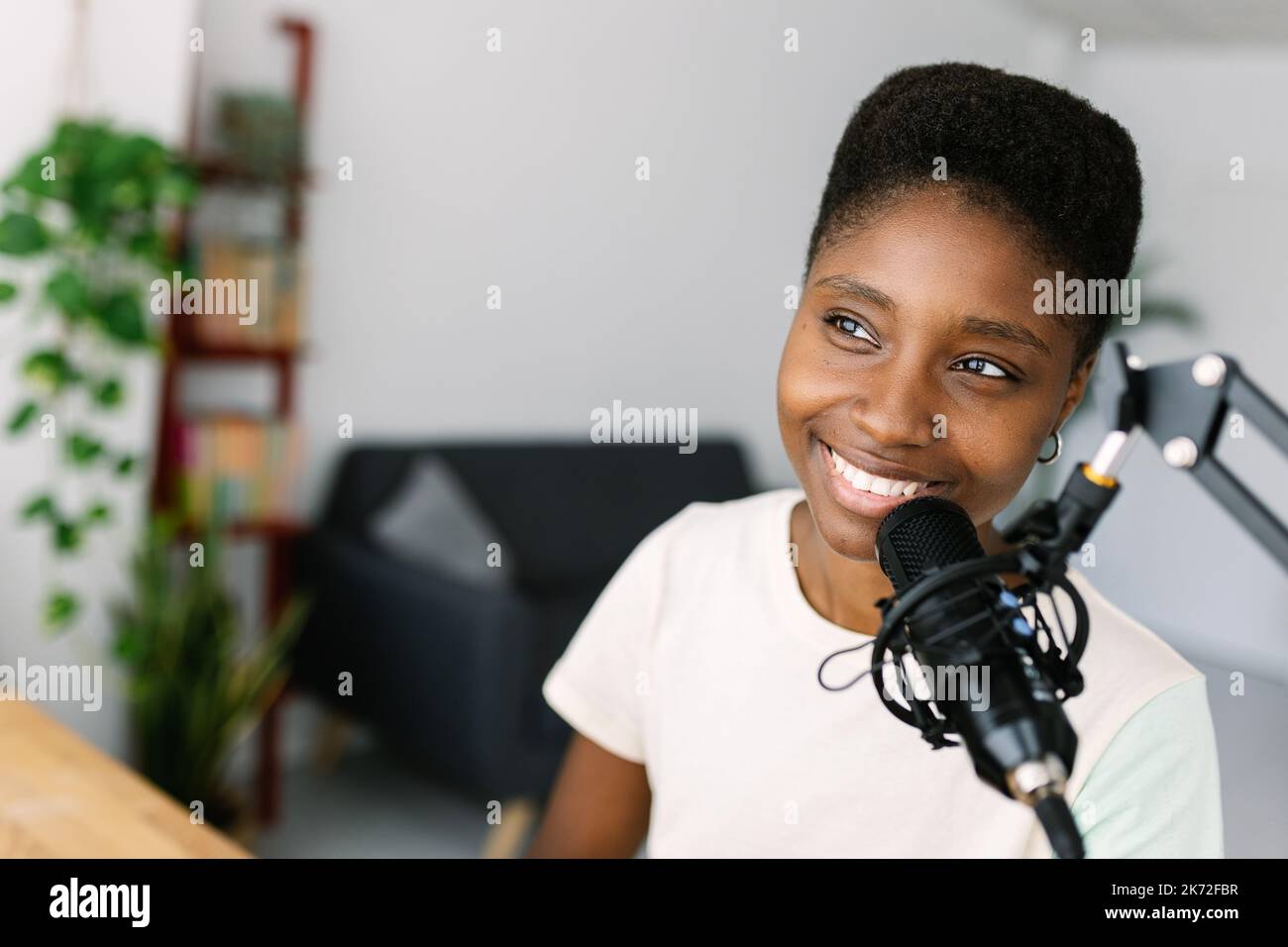 Young african american content creator woman recording podcast on home studio Stock Photo