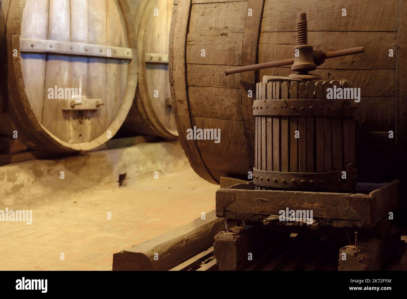 Ancient underground wine cellar with wooden oak casks for wine aging