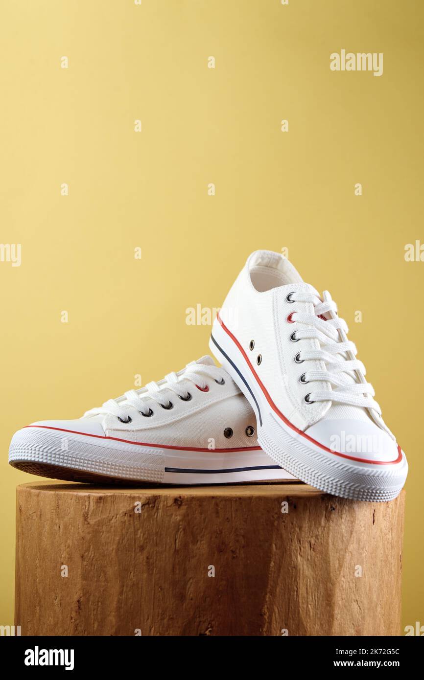 Pair of trendy shoes on yellow background. Sport sneakers with copy space, Summer footwear concept Stock Photo
