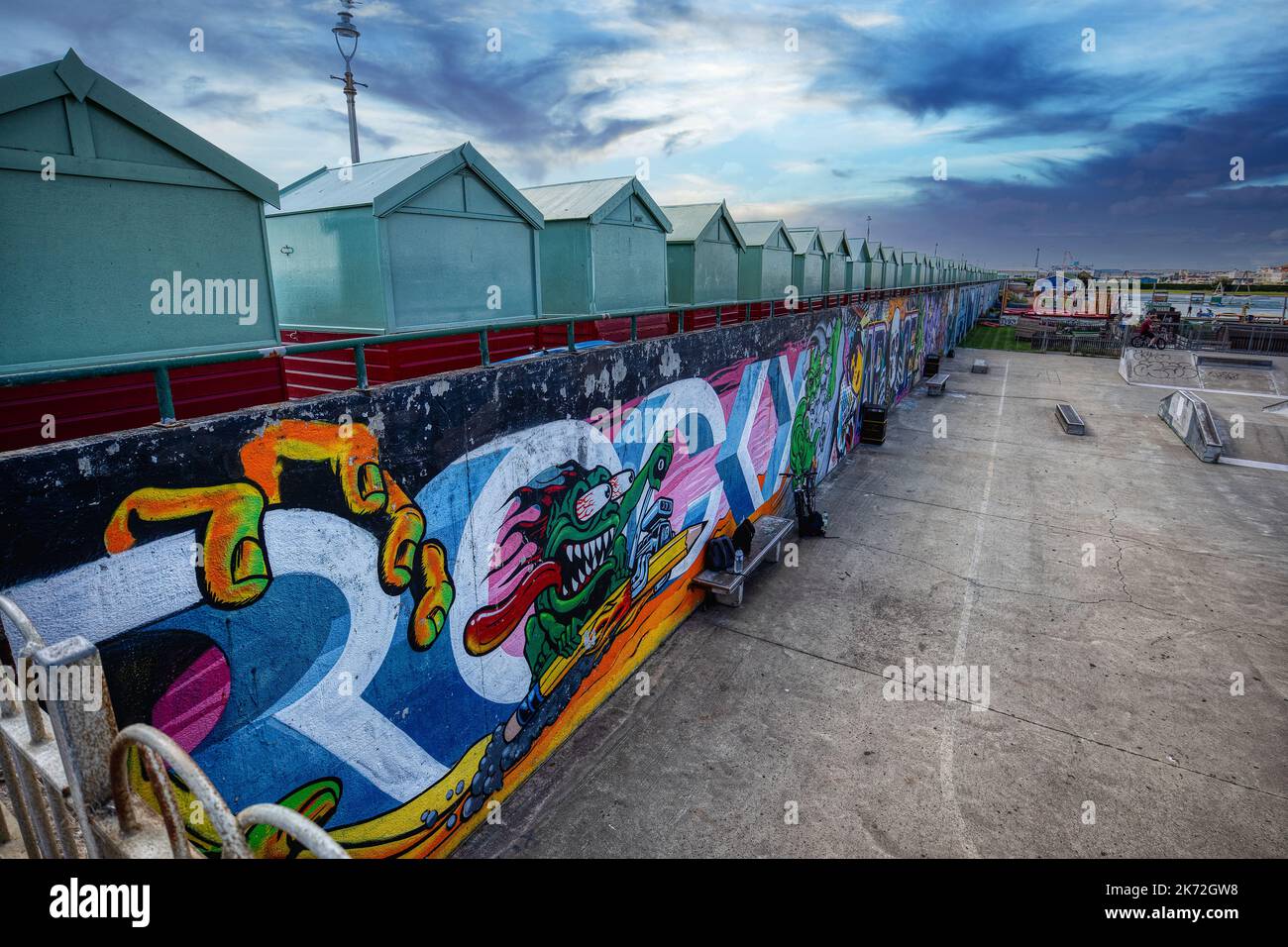 The skate park at The Big Beach Cafe owned by Fat Boy Slim (Norman Cook) on Hove seafront with the beach huts and coilourful street art against a dram Stock Photo