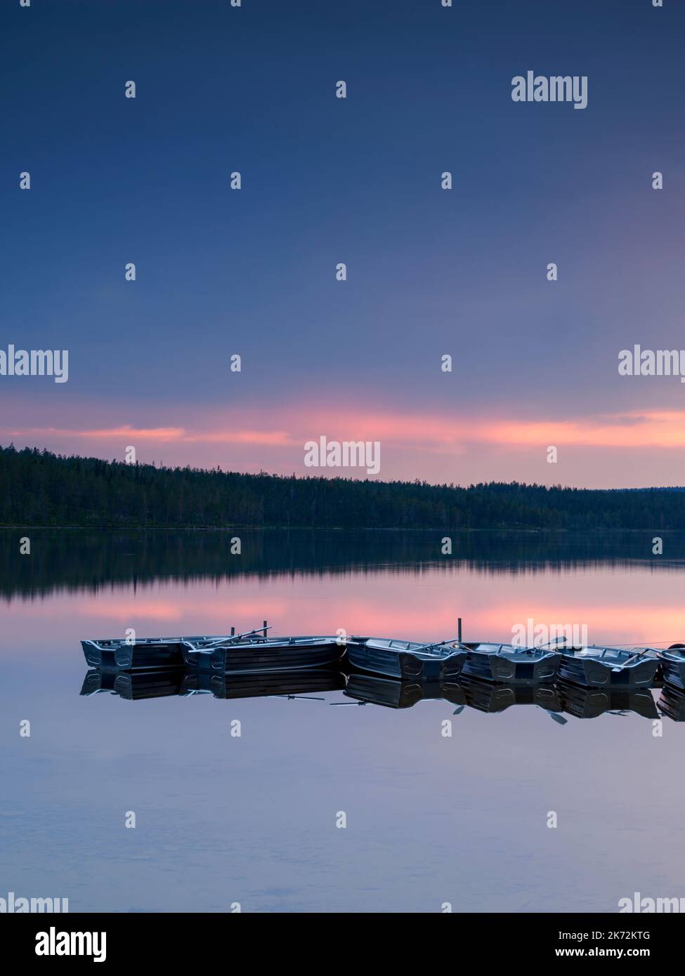 Rowing boats at lake at sunset Stock Photo - Alamy