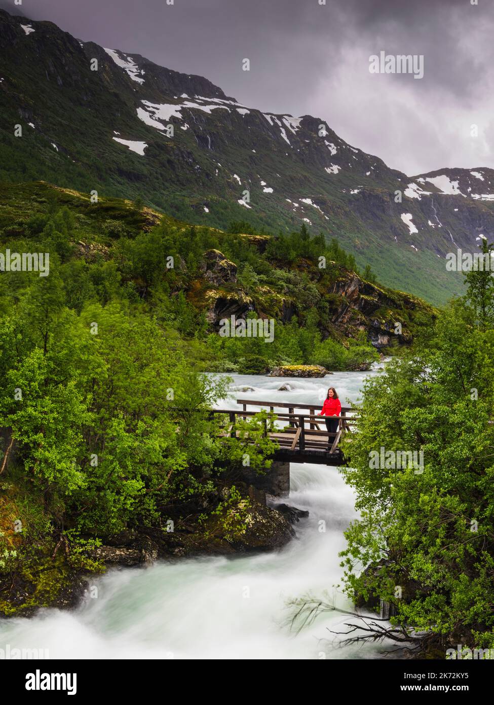 Female hiker standing on bridge over river Stock Photo - Alamy