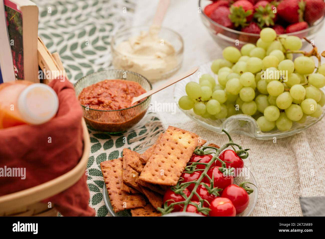 Fruit, vegetables, and crackers on picnic blanket Stock Photo