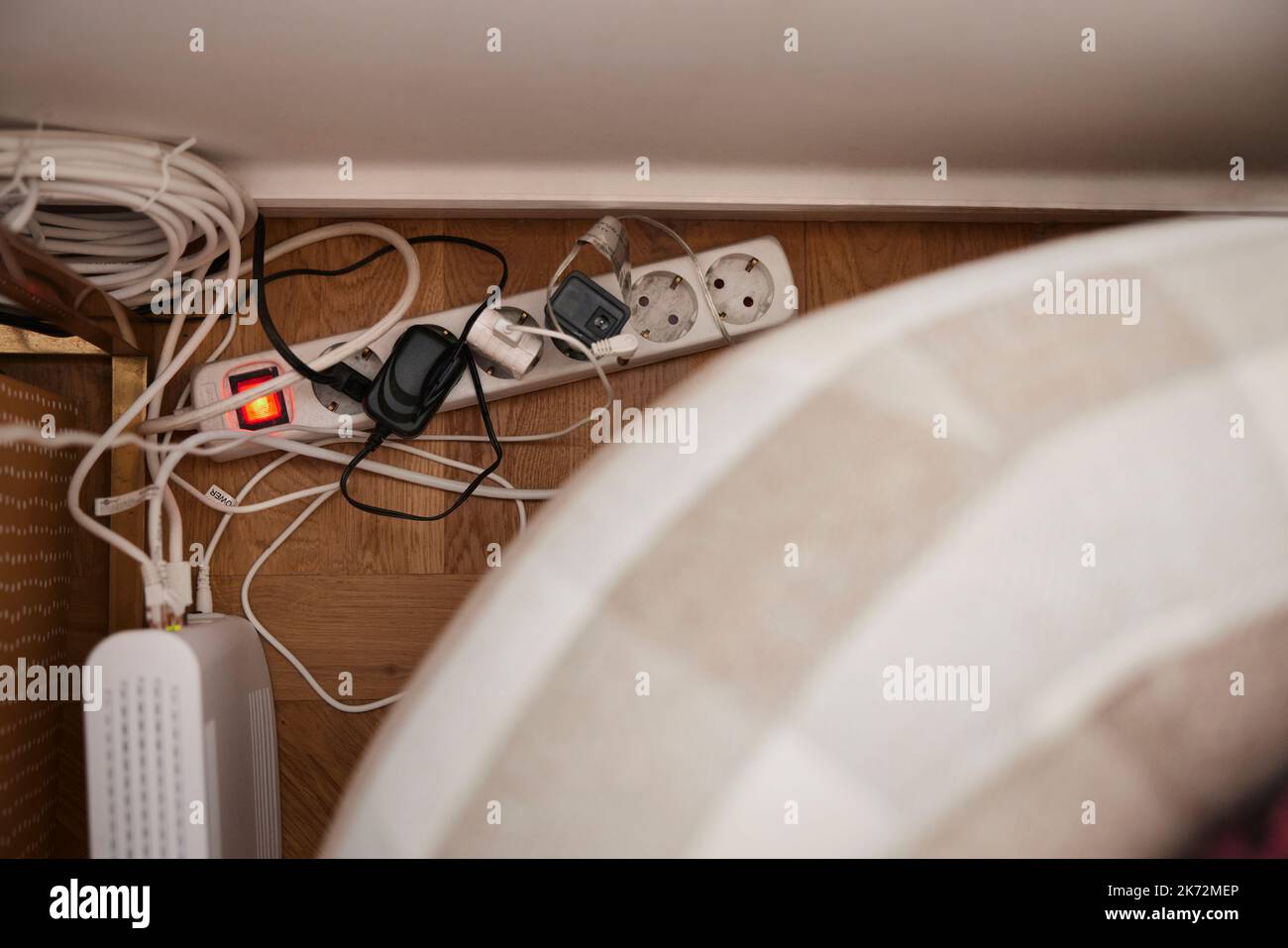 Plugs in extension cord behind sofa Stock Photo Alamy