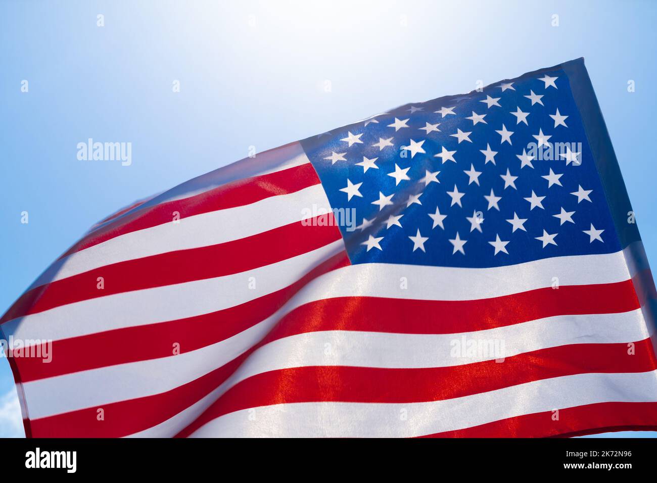 American flag waving in the wind against blue sky Stock Photo - Alamy