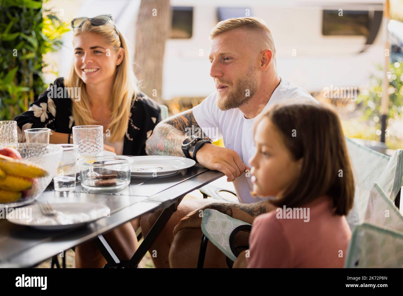 Family sitting at picnic table Stock Photo Alamy
